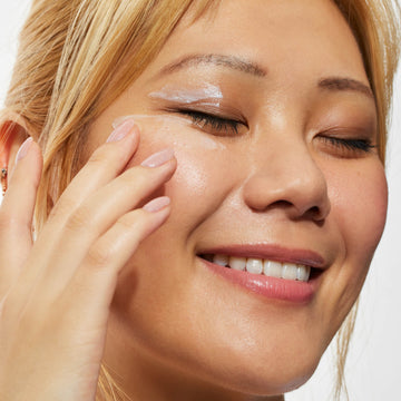 Woman applying cream to her face with a close-up view
